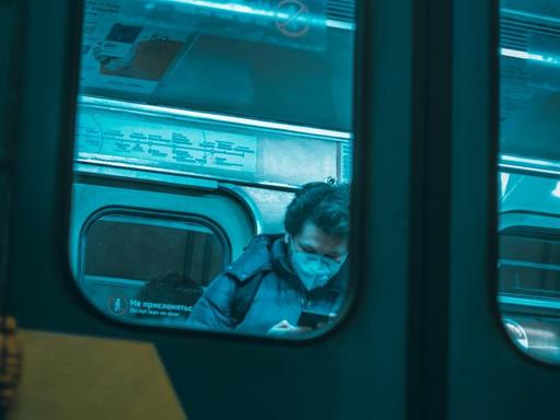 Ein Mann in einem Zugwaggon in Moskau. Mit Maske.