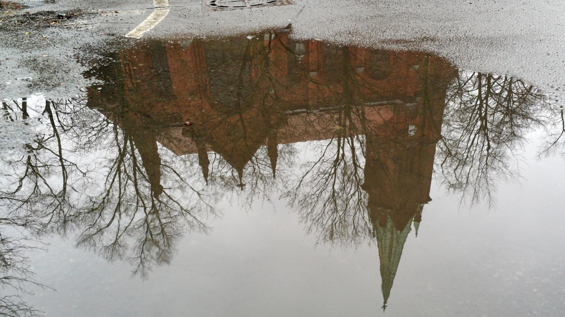 Die Türme der Gethsemanekirche in Berlin Prenzlauer Berg spiegeln sich in einer Pfütze. Die Türme der Gethsemanekirche in Berlin Prenzlauer Berg spiegeln sich in einer Pfütze.