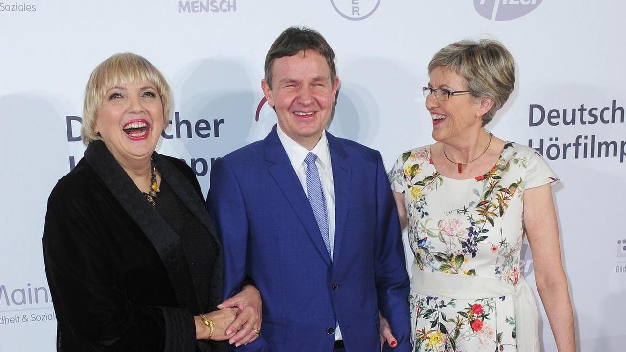 Claudia Roth, Andreas Bethke und Renate Reymann stehen beim Deutschen Hörfilmpreis 2017 vor einer Werbewand. Claudia Roth, Andreas Bethke und Renate Reymann stehen beim Deutschen Hörfilmpreis 2017 vor einer Werbewand.