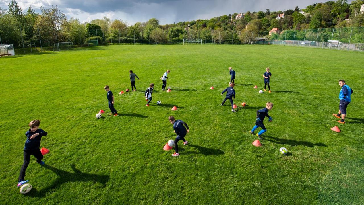 Fußballer der Altersklasse U-10 vom SV Loschwitz trainieren auf dem Spielfeld in großen Abständen.
