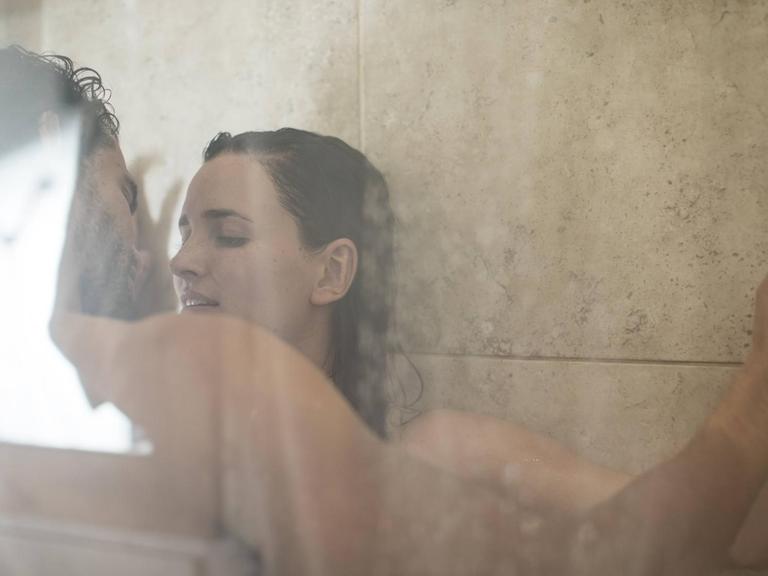 Ein Paar küsst sich während des Duschens