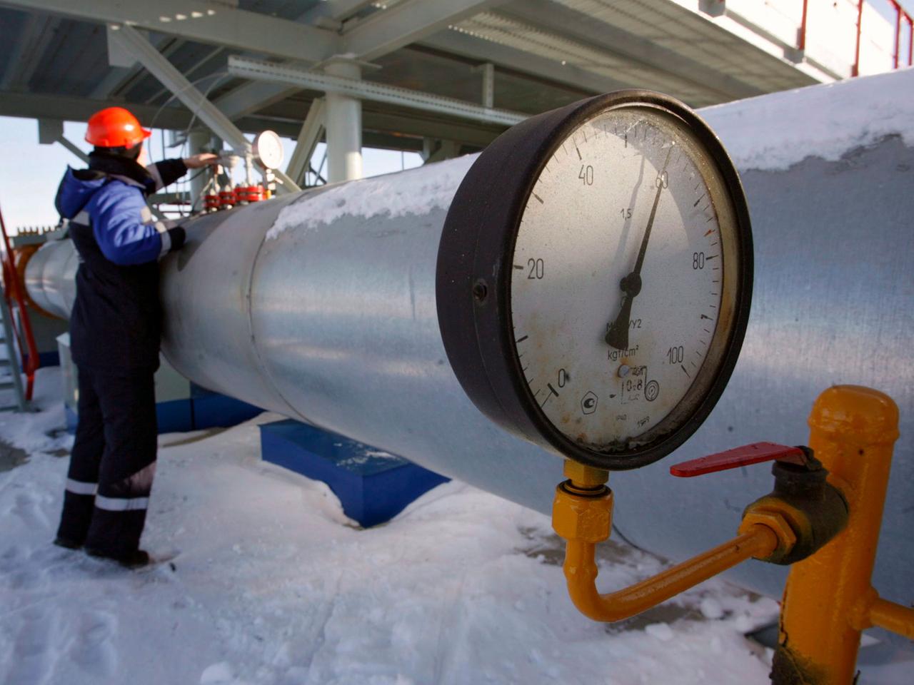 Ein Mann steht an einer Gaspipeline. Ein Mann steht an einer Gaspipeline.