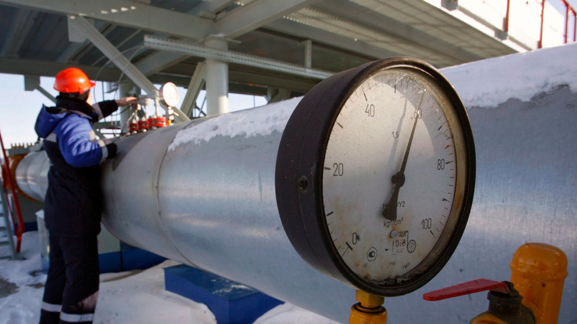 Ein Mann steht an einer Gaspipeline. Ein Mann steht an einer Gaspipeline.