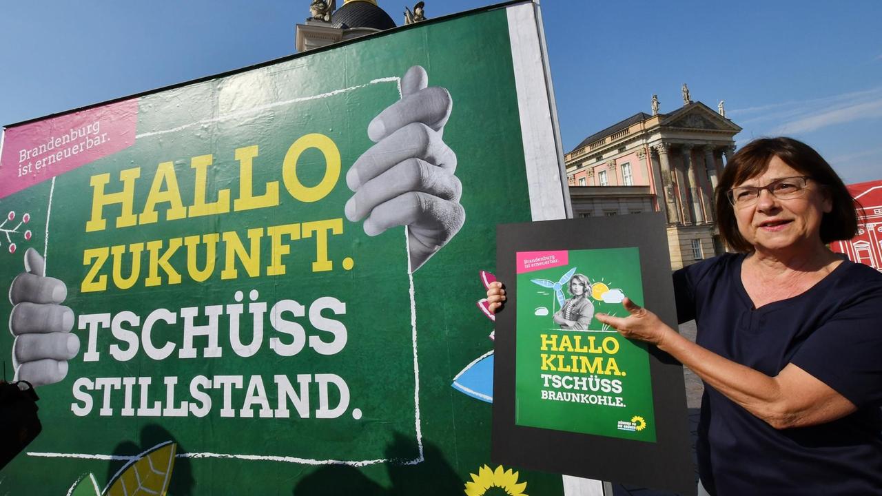 06.06.2019, Brandenburg, Potsdam: Die Spitzenkandidatin von Bündnis 90/Die Grünen der Landtagswahl, Ursula Nonnemacher, stellt am Landtag das Großplakat zur Wahl vor und das kleine Plakat "Hallo Klima Tschüss Braunkohle". 06.06.2019, Brandenburg, Potsdam: Die Spitzenkandidatin von Bündnis 90/Die Grünen der Landtagswahl, Ursula Nonnemacher, stellt am Landtag das Großplakat zur Wahl vor und das kleine Plakat "Hallo Klima Tschüss Braunkohle".