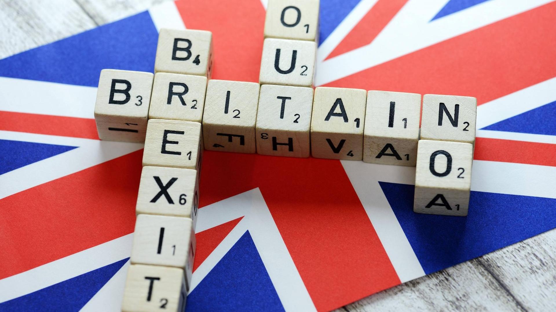 Buchstabenwürfel formen die Begriffe Britain, Brexit, Out und No auf der Fahne von Großbritannien, Buchstabenwürfel formen die Begriffe Britain, Brexit, Out und No auf der Fahne von Großbritannien,