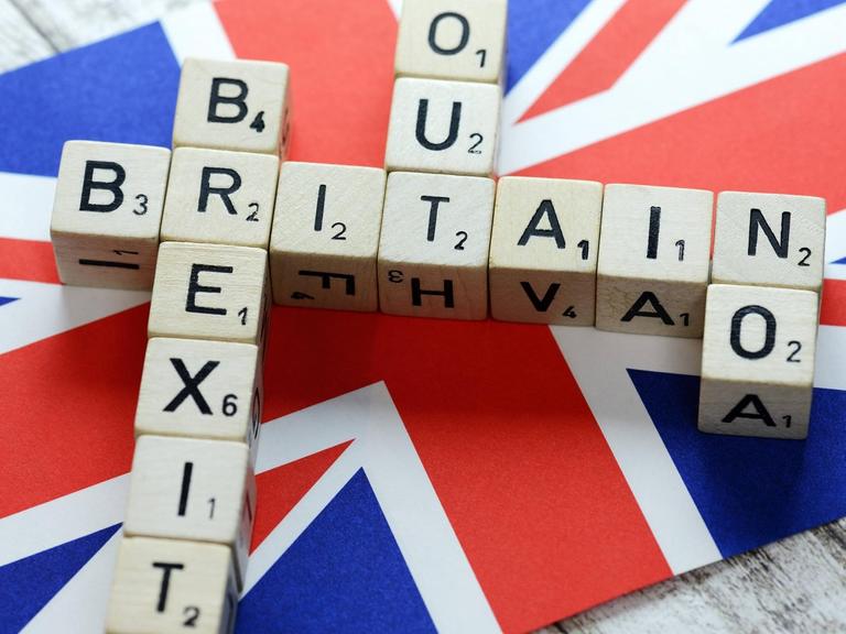 Buchstabenwürfel formen die Begriffe Britain, Brexit, Out und No auf der Fahne von Großbritannien
