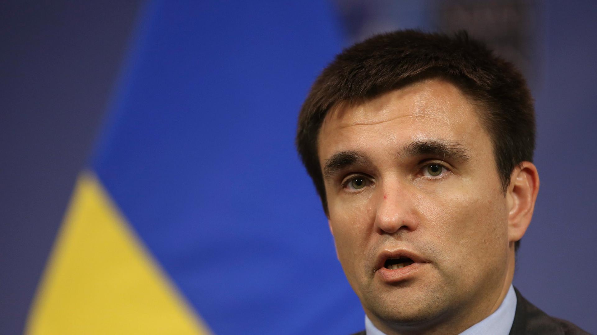 Der ukrainische Außenminster Pawel Klimkin, sprechend, eine gelb-blaue Fahne im Hintergrund. Der ukrainische Außenminster Pawel Klimkin, sprechend, eine gelb-blaue Fahne im Hintergrund.