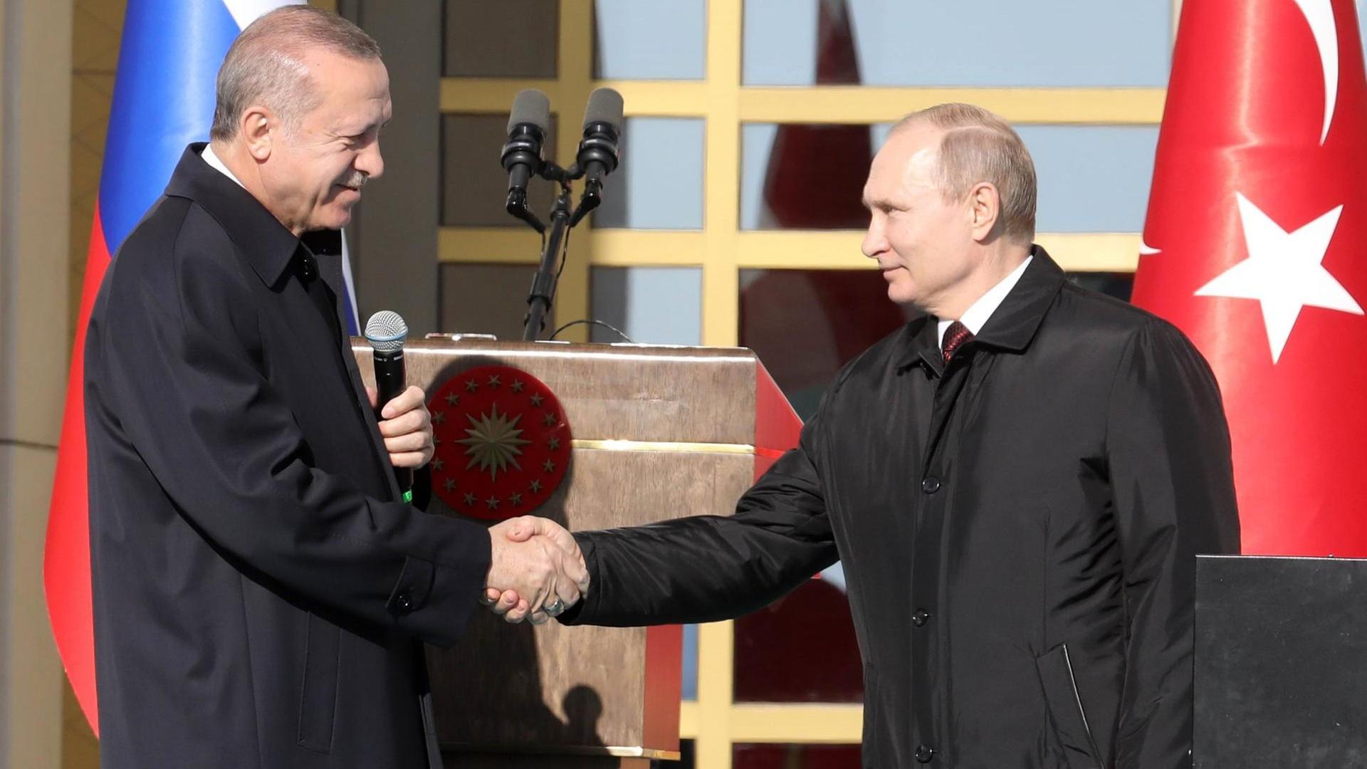 Der türkische Präsident Recep Tayyip Erdogan und Russlands Präsident Wladimir Putin schütteln sich die Hände bei der Auftaktzeremonie für den Bau des ersten Atomkraftwerks auf türkischem Boden, das mit Moskaus Hilfe entsteht Der türkische Präsident Recep Tayyip Erdogan und Russlands Präsident Wladimir Putin schütteln sich die Hände bei der Auftaktzeremonie für den Bau des ersten Atomkraftwerks auf türkischem Boden, das mit Moskaus Hilfe entsteht