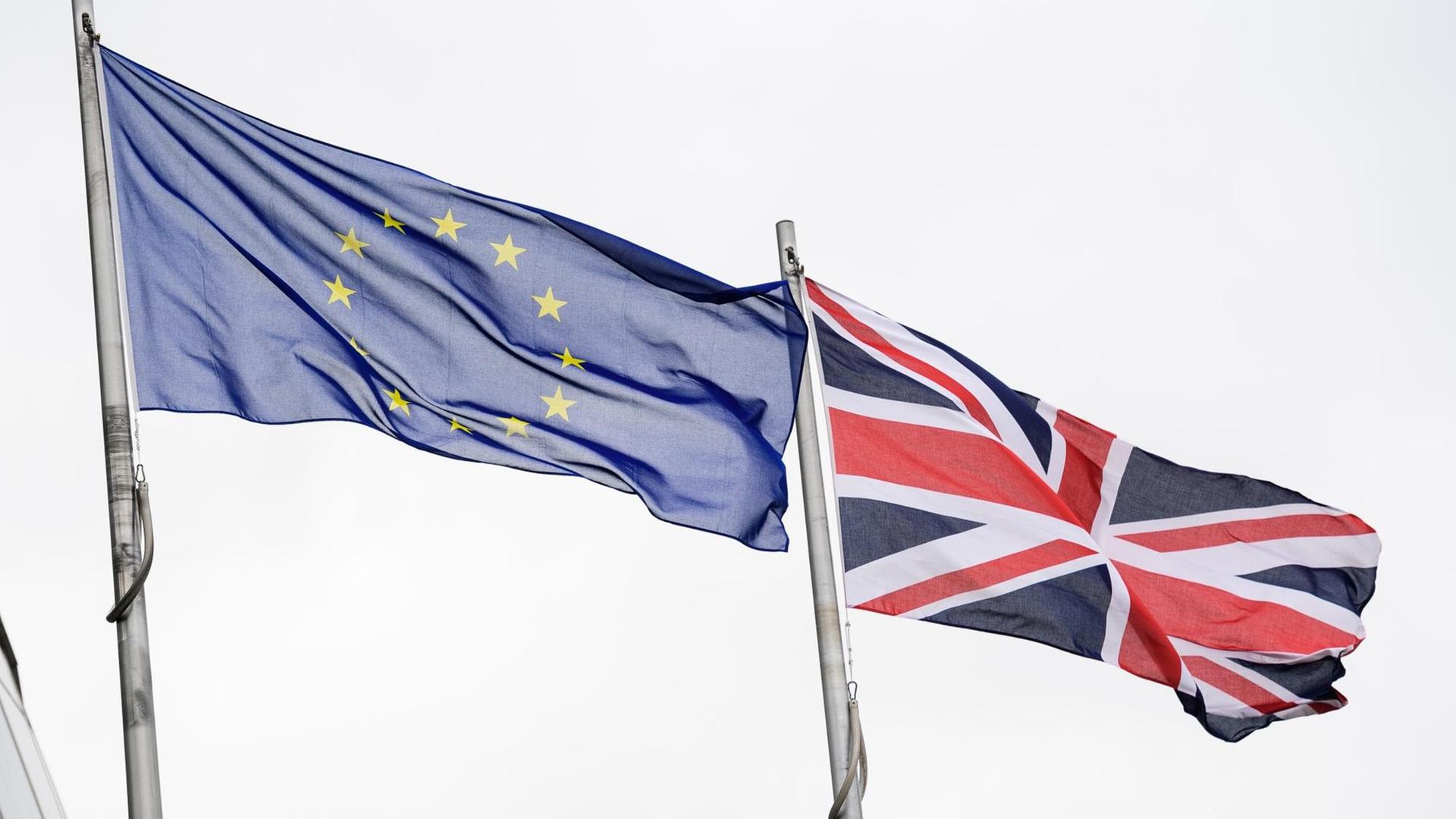 EU-Flagge und Großbritannien-Flagge wehen im Wind EU-Flagge und Großbritannien-Flagge wehen im Wind