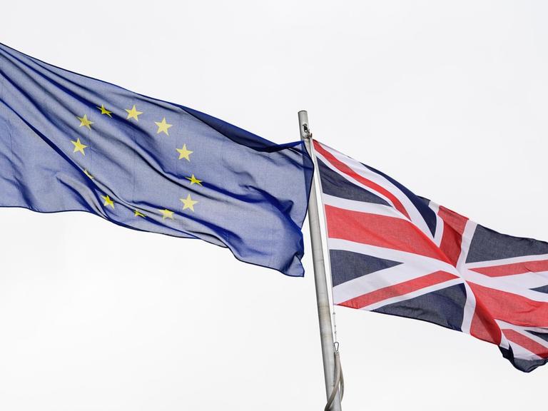 EU-Flagge und Großbritannien-Flagge wehen im Wind