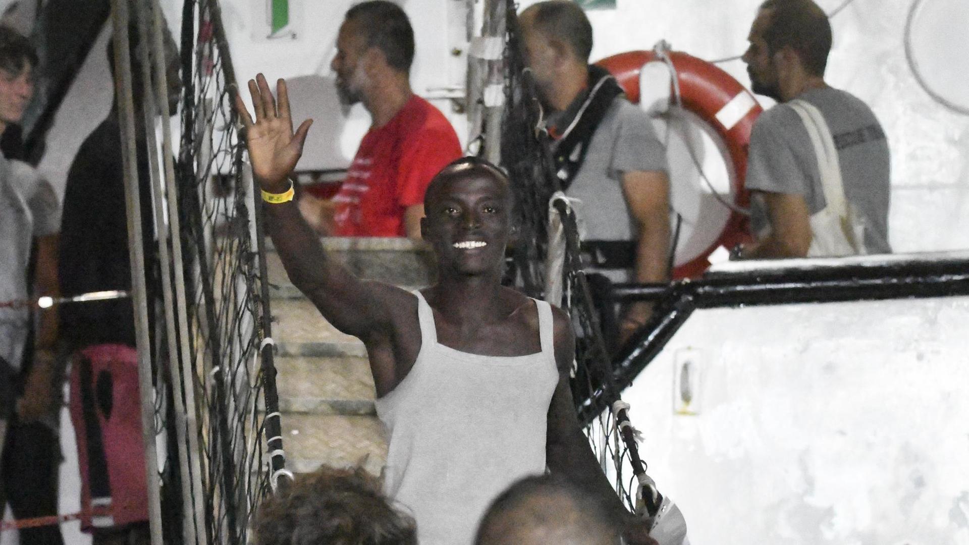 Ein Mann winkt, nachdem er mit dem Rettungsschiff «Open Arms» auf der italienischen Insel Lampedusa angekommen ist. Ein Mann winkt, nachdem er mit dem Rettungsschiff «Open Arms» auf der italienischen Insel Lampedusa angekommen ist.