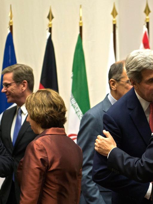 EU-Außenbeauftragte Catherine Asthon (2. von links, 1. Reihe) spricht mit dem iranischen Außenminister Mohmammad-Javad Zariv (1. von links, 1. Reihe), während der US-Außenminister John Kerry (2. von rechts) den französischen Außenminister Laurent Fabius (1. von rechts) begrüßt.