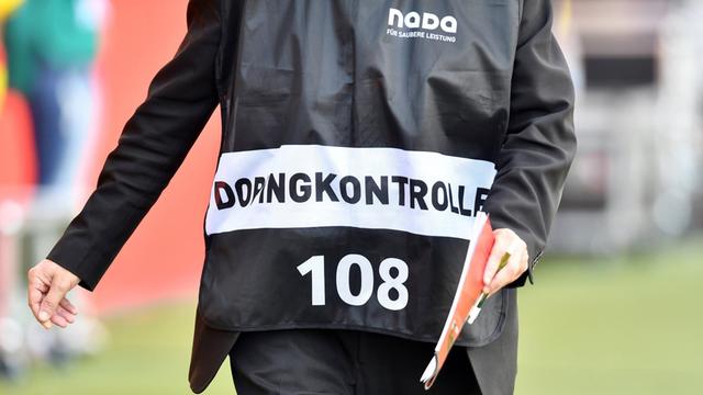 Ein Dopingkontrolleur der NADA (Nationale Anti-Doping-Agentur) bestellt einen Spieler zur Dopingprobe.