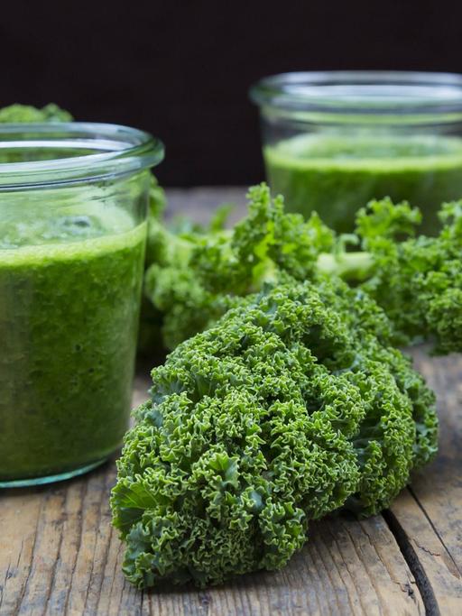 Zwei Gläser mit grünem Smoothie aus Grünkohl.