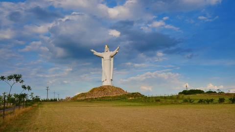 Die golden gekrönte Christusstatue, erbaut in der Stadt Swiebodzin in Woiwodschaft Lubusz im Jahr 2010, gilt als die höchste Jesusstatue der Welt gilt. Um sie herum sind Felder zu sehen.