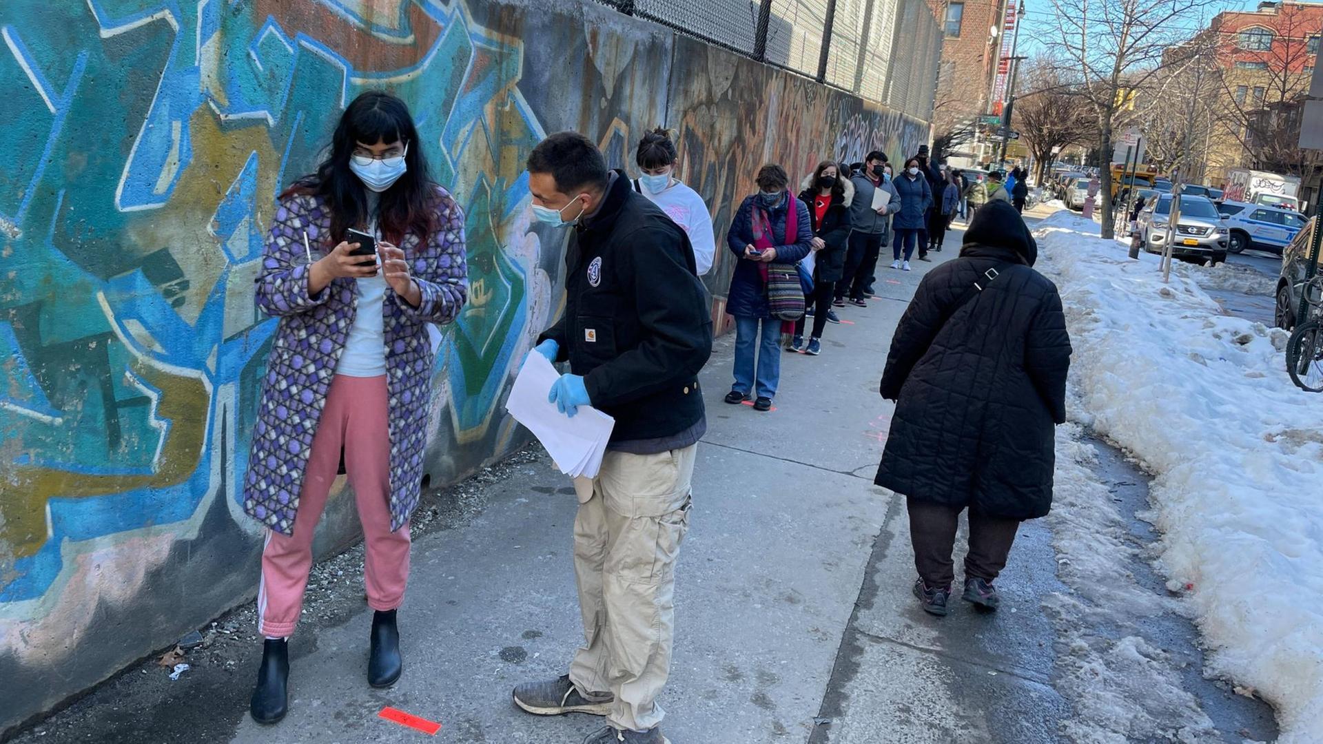 Vor einem Impfzentrum im New Yorker Stadtteil Brooklyn stehen die Menschen in einer langen Warteschlange. Vor einem Impfzentrum im New Yorker Stadtteil Brooklyn stehen die Menschen in einer langen Warteschlange.