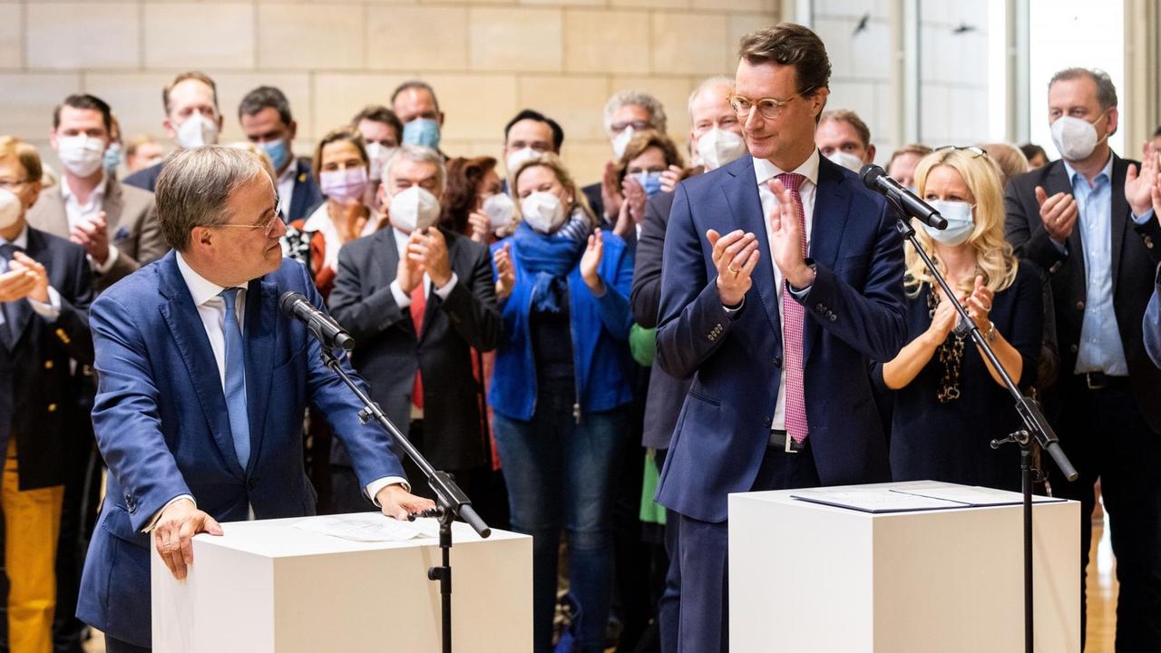 Armin Laschet (l, CDU), Ministerpräsident von Nordrhein-Westfalen, steht neben Hendrik Wüst (CDU), Verkehrsminister von Nordrhein-Westfalen, während eines Statements. 