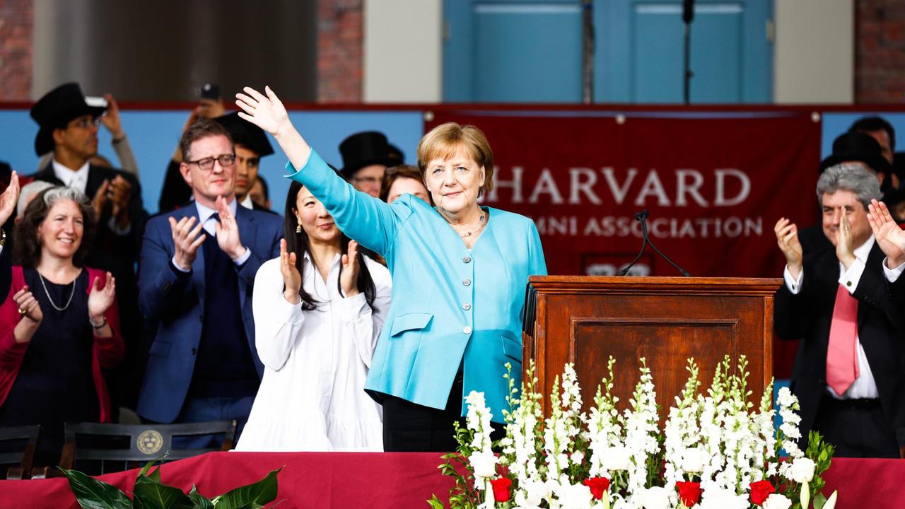 30.05.2019, USA, Cambridge: Bundeskanzlerin Angela Merkel (CDU) winkt den Zuhörern nach ihrer Rede in der Harvard Universität. In einer emotionalen Rede an der US-Eliteuniversität Harvard hat Kanzlerin Merkel für internationale Zusammenarbeit und gegenseitigen Respekt geworben - und sich scharf von US-Präsident Trump abgegrenzt. Foto: Omar Rawlings/dpa | Verwendung weltweit 30.05.2019, USA, Cambridge: Bundeskanzlerin Angela Merkel (CDU) winkt den Zuhörern nach ihrer Rede in der Harvard Universität. In einer emotionalen Rede an der US-Eliteuniversität Harvard hat Kanzlerin Merkel für internationale Zusammenarbeit und gegenseitigen Respekt geworben - und sich scharf von US-Präsident Trump abgegrenzt. Foto: Omar Rawlings/dpa | Verwendung weltweit
