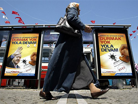 Eine türkische Frau geht in Istanbul an Wahlplakaten vorbei.
