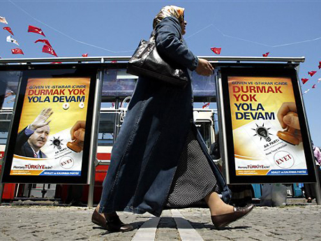 Eine türkische Frau geht in Istanbul an Wahlplakaten vorbei. Eine türkische Frau geht in Istanbul an Wahlplakaten vorbei.