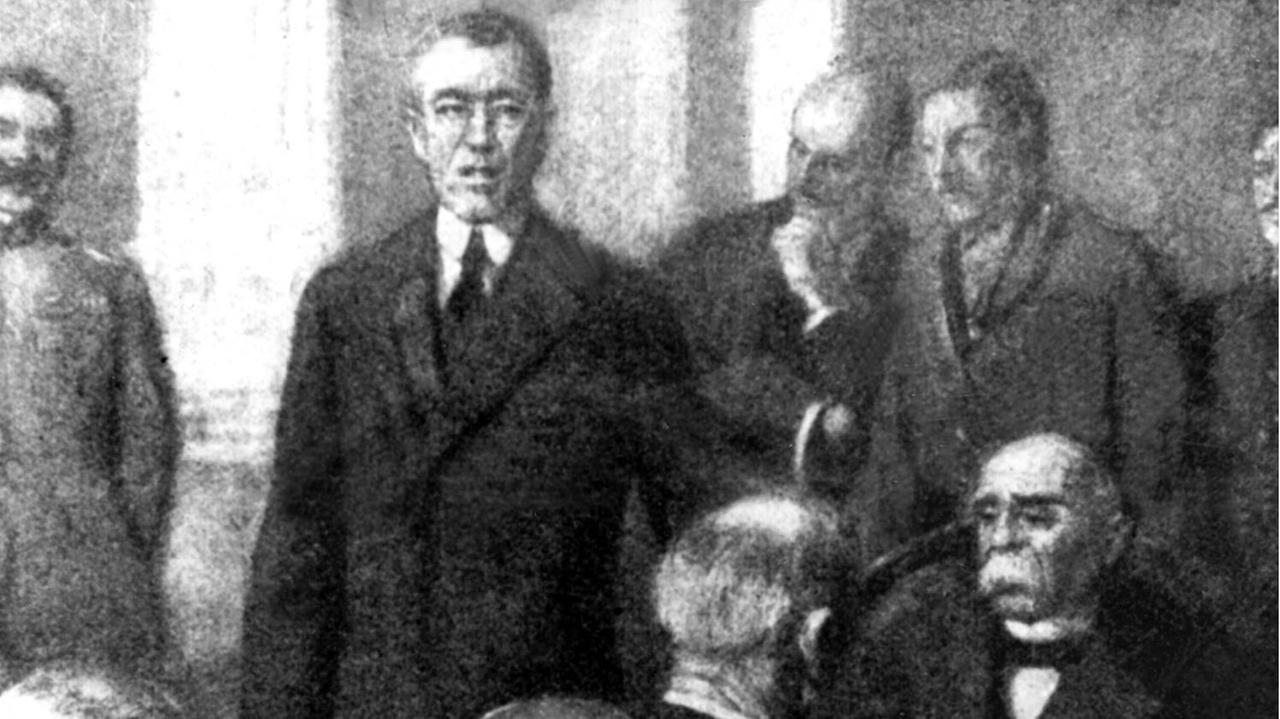Der amerikanische Präsident Woodrow Wilson während seiner Eröffnungsrede. Rechts mit Schnauzbart der französische Ministerpräsident Georges Benjamin Clemenceau. Der Versailler Vertrag war der wichtigste der Pariser Vorortverträge, die 1919/20 den 1. Weltkrieg beendeten.