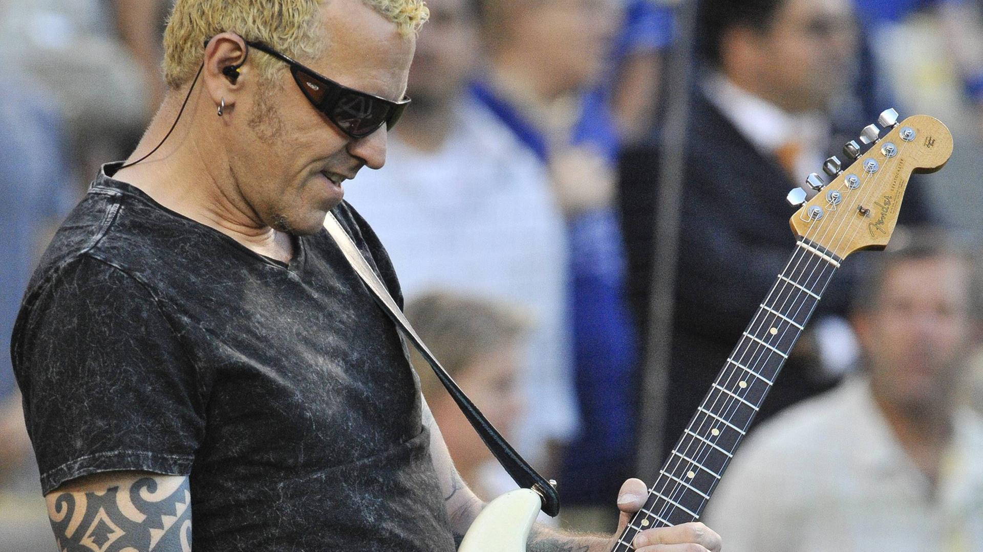 Der US-amerikanische Musiker Gary Hoey spielt bei einem Auftritt in Los Angeles im August 2010 auf einer E-Gitarre und trägt eine Sonnenbrille.