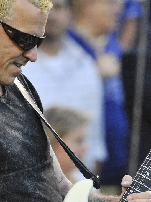 Der US-amerikanische Musiker Gary Hoey spielt bei einem Auftritt in Los Angeles im August 2010 auf einer E-Gitarre und trägt eine Sonnenbrille.
