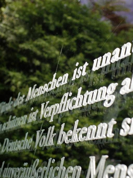 Artikel 1 des Deutschen Grundgesetzes . Die Wuerde des Menschen ist unantastbar . Kunstwerk Grundgesetz 49 des israelische Kuenstlers Dani Karavan an den Buerogebaeuden des Deutschen Bundestags . Berlin , Deutschland .