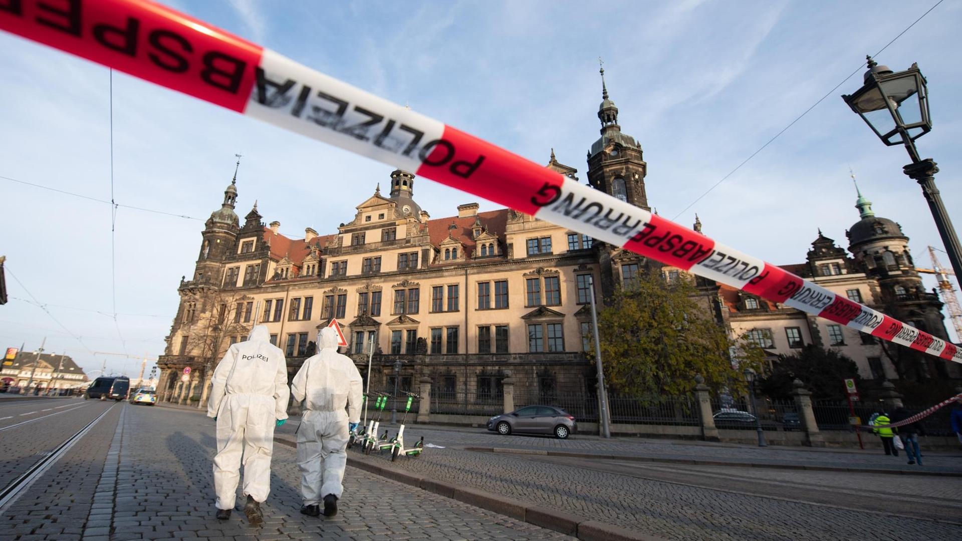 Zwei Mitarbeiter der Spurensicherung vor dem Residenzschloss mit dem Grünen Gewölbe hinter einem Absperrband Zwei Mitarbeiter der Spurensicherung vor dem Residenzschloss mit dem Grünen Gewölbe hinter einem Absperrband