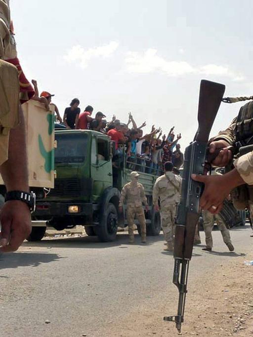 Die irakische Armee transportiert Freiwillige auf Militär-Lastwagen nach Bagdad.
