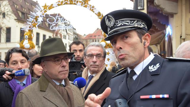 Der französische Premierminister Bernard Cazeneuve (l.) spricht mit dem Polizeidirektor Jean-Francois Illy (r.) auf dem Weihnachtsmarkt in Straßburg.