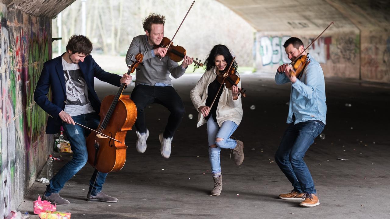 Die vier Musiker spielen, rocken, hüpfen und springen in einem dunklen Tunnel Die vier Musiker spielen, rocken, hüpfen und springen in einem dunklen Tunnel
