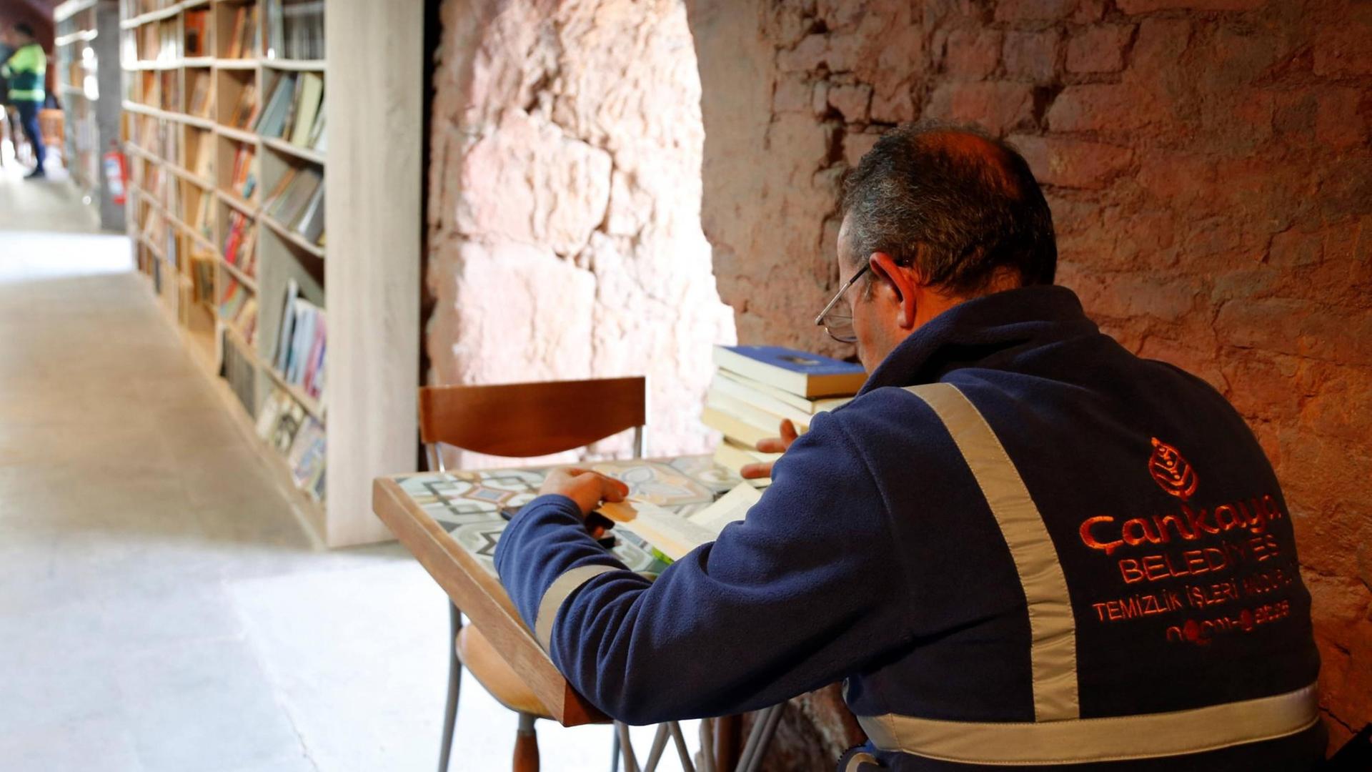 Ein Arbeiter sitzt in der Bücherei der Müllmänner von Ankara, die in einer ehemaligen Ziegelsteinfabrik im Stadtteil Cankaya eingerichtet wurde, und liest Ein Arbeiter sitzt in der Bücherei der Müllmänner von Ankara, die in einer ehemaligen Ziegelsteinfabrik im Stadtteil Cankaya eingerichtet wurde, und liest