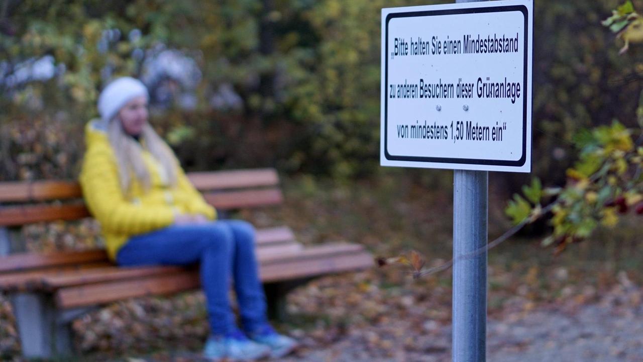Parkanlagen in Bad Wörishofen, Wegen der Corona-Pandemie soll man Abstand halten. Die Stadt hat ein Schild dazu aufgestellt: Bitte halten Sie einen Mindestabstand zu anderen Besuchern dieser Grünanlage von mindestens 1,50 Metern ein Verstöße kosten 150 Euro Bußgeld. Frau sitzt alleine auf der Parkbank. Parkanlagen in Bad Wörishofen, Wegen der Corona-Pandemie soll man Abstand halten. Die Stadt hat ein Schild dazu aufgestellt: Bitte halten Sie einen Mindestabstand zu anderen Besuchern dieser Grünanlage von mindestens 1,50 Metern ein Verstöße kosten 150 Euro Bußgeld. Frau sitzt alleine auf der Parkbank.