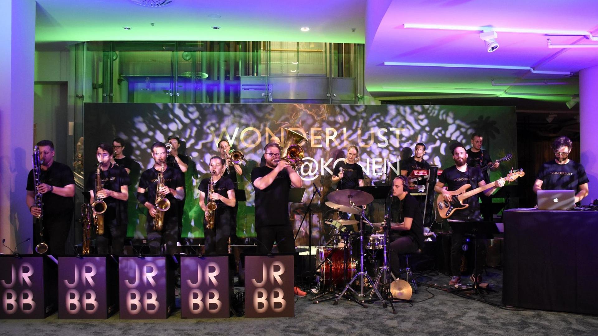 Jazzrausch Big Band auf der Bühne bei einer Veranstaltung in München. Die Band spielt, im Hintergrund grünes und violette Lichteffekte. Jazzrausch Big Band auf der Bühne bei einer Veranstaltung in München. Die Band spielt, im Hintergrund grünes und violette Lichteffekte.