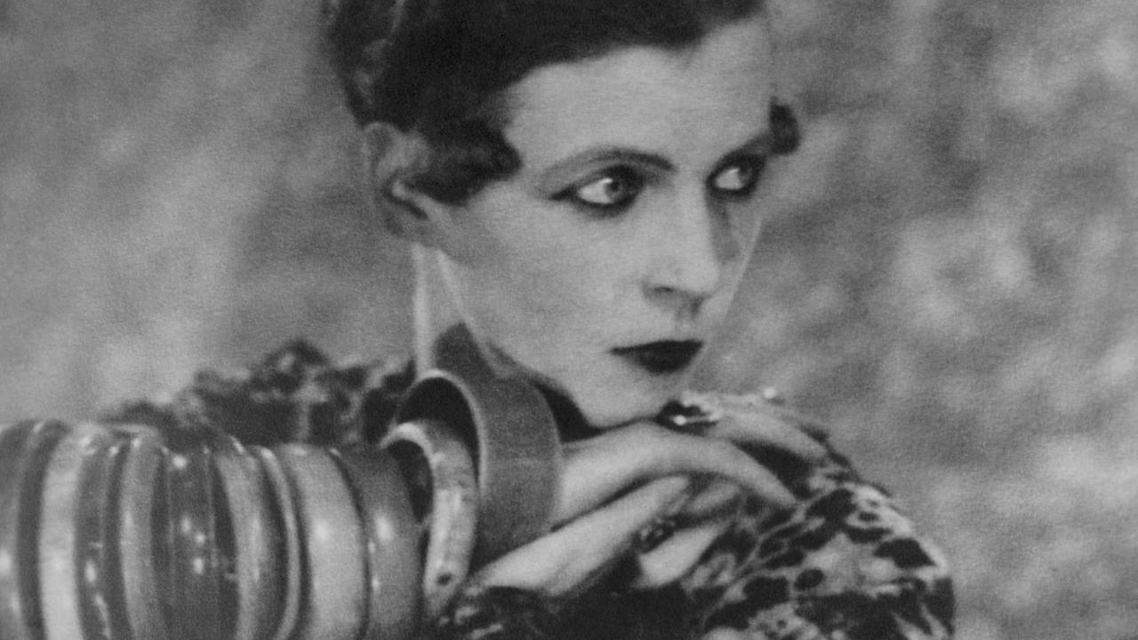 Nancy Cunard auf einer historischen Schwarz-Weiß-Aufnahme. Nancy Cunard auf einer historischen Schwarz-Weiß-Aufnahme.