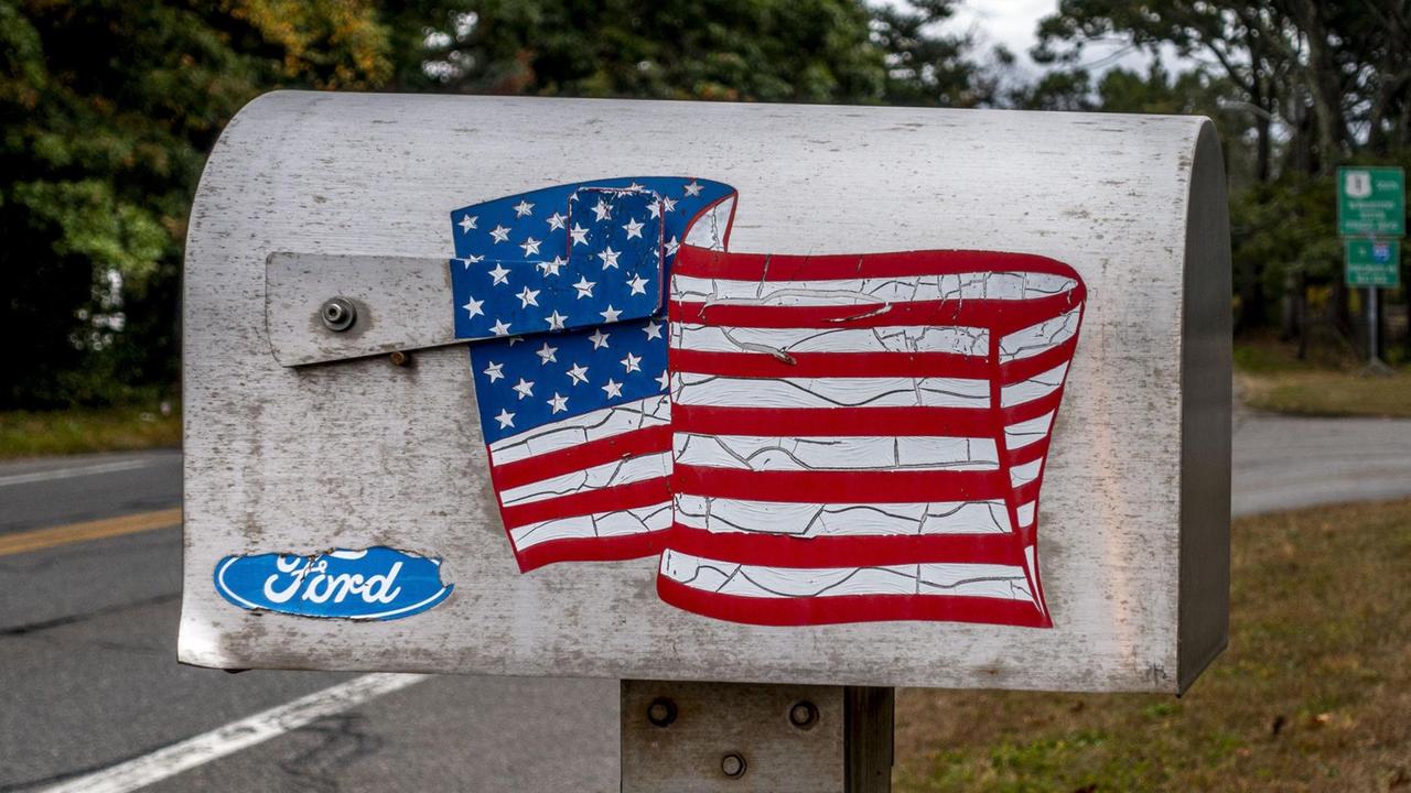 Ein typischer Briefkasten mit einer wehenden US-Flagge steht an einer Straße unweit von Boston, Massachusetts Ein typischer Briefkasten mit einer wehenden US-Flagge steht an einer Straße unweit von Boston, Massachusetts
