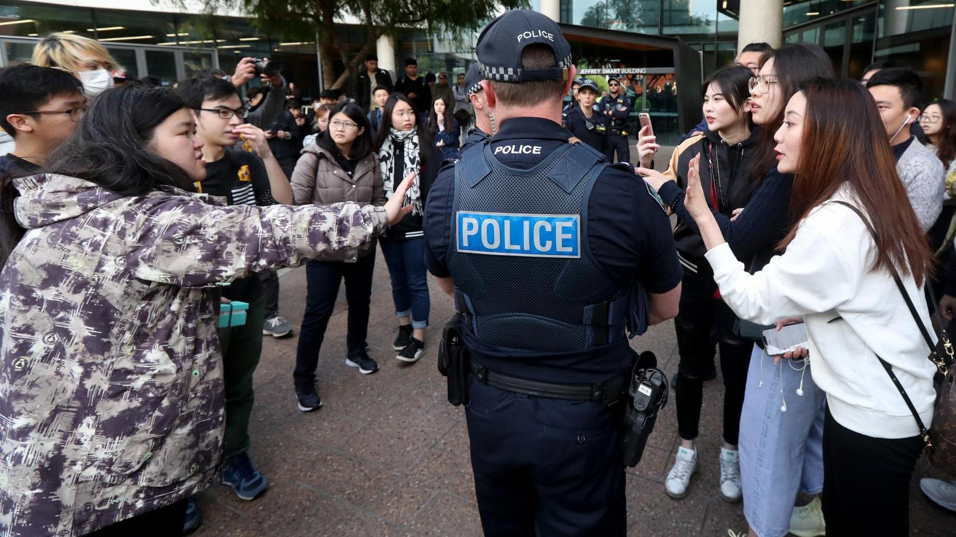 Australische Polizisten trennen Pro-China- und Pro-Hongkong-Demonstranten vor der University of South Australia. Australische Polizisten trennen Pro-China- und Pro-Hongkong-Demonstranten vor der University of South Australia.