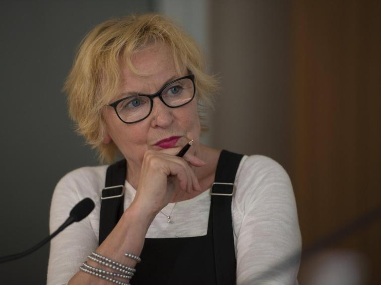 Bascha Mika 2016 in ihrer damaligen Funktion als Chefredakteurin der Frankfurter Rundschau. Sie trägt eine Brille und hält einen Kugelschreiber in Ihrer Hand.