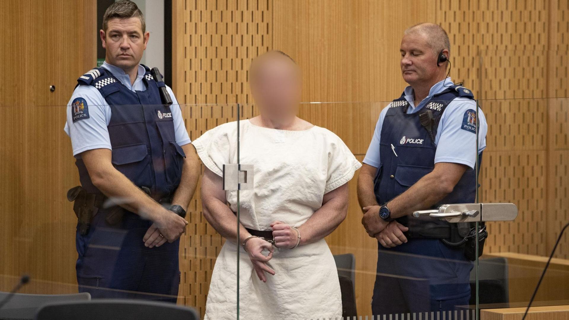 2 Polizisten halten den Mann am Arm. 2 Polizisten halten den Mann am Arm.