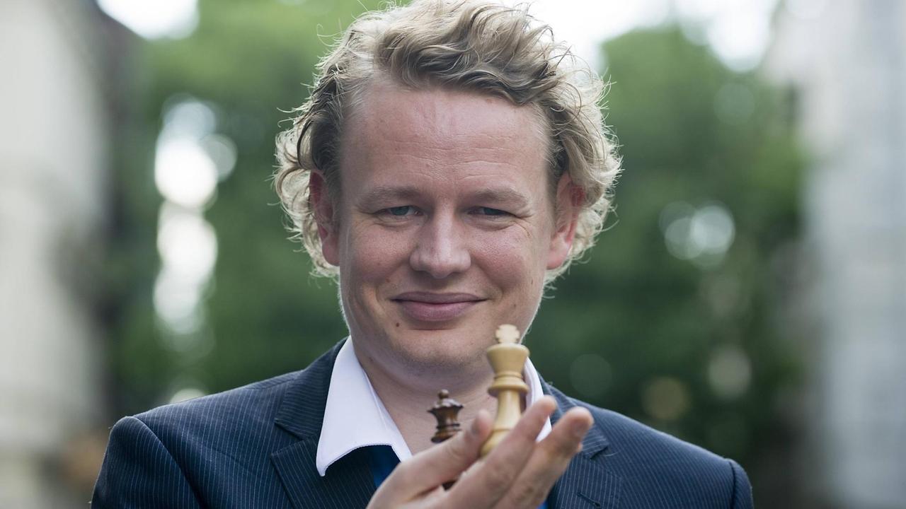 Der Blitzschachmeister Jan Gustavsson hält Spielsteine in der Hand Der Blitzschachmeister Jan Gustavsson hält Spielsteine in der Hand