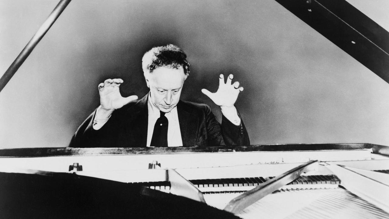 Pianist Arthur Rubinstein sitzt am Flügel im Jahr 1951 und reißt die Hände nach oben. Pianist Arthur Rubinstein sitzt am Flügel im Jahr 1951 und reißt die Hände nach oben.