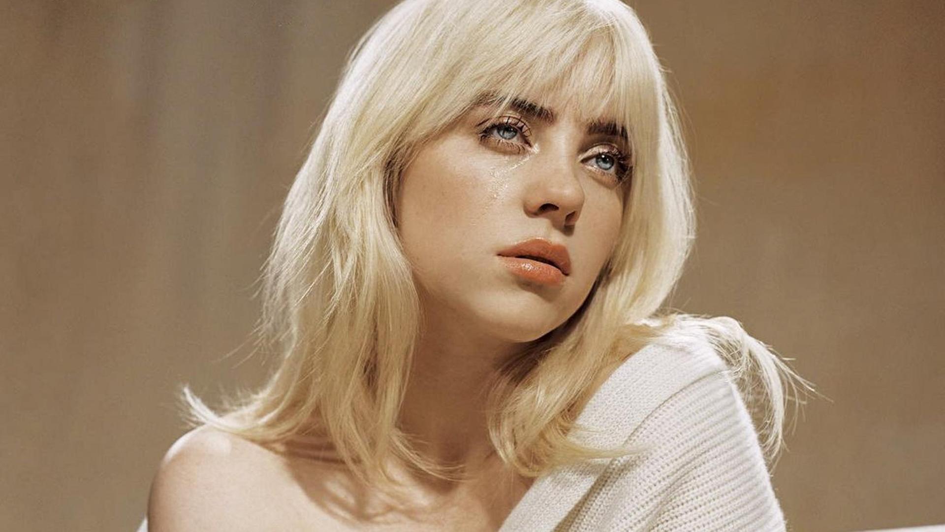 Screenshot eines Social-Media-Posts der Musikerin Billie Eilish: Das Oberkörperporträt zeigt die Sängerin in einem cremefarbenen, schulterfreien Pullover und mit blondiertem Haar.
