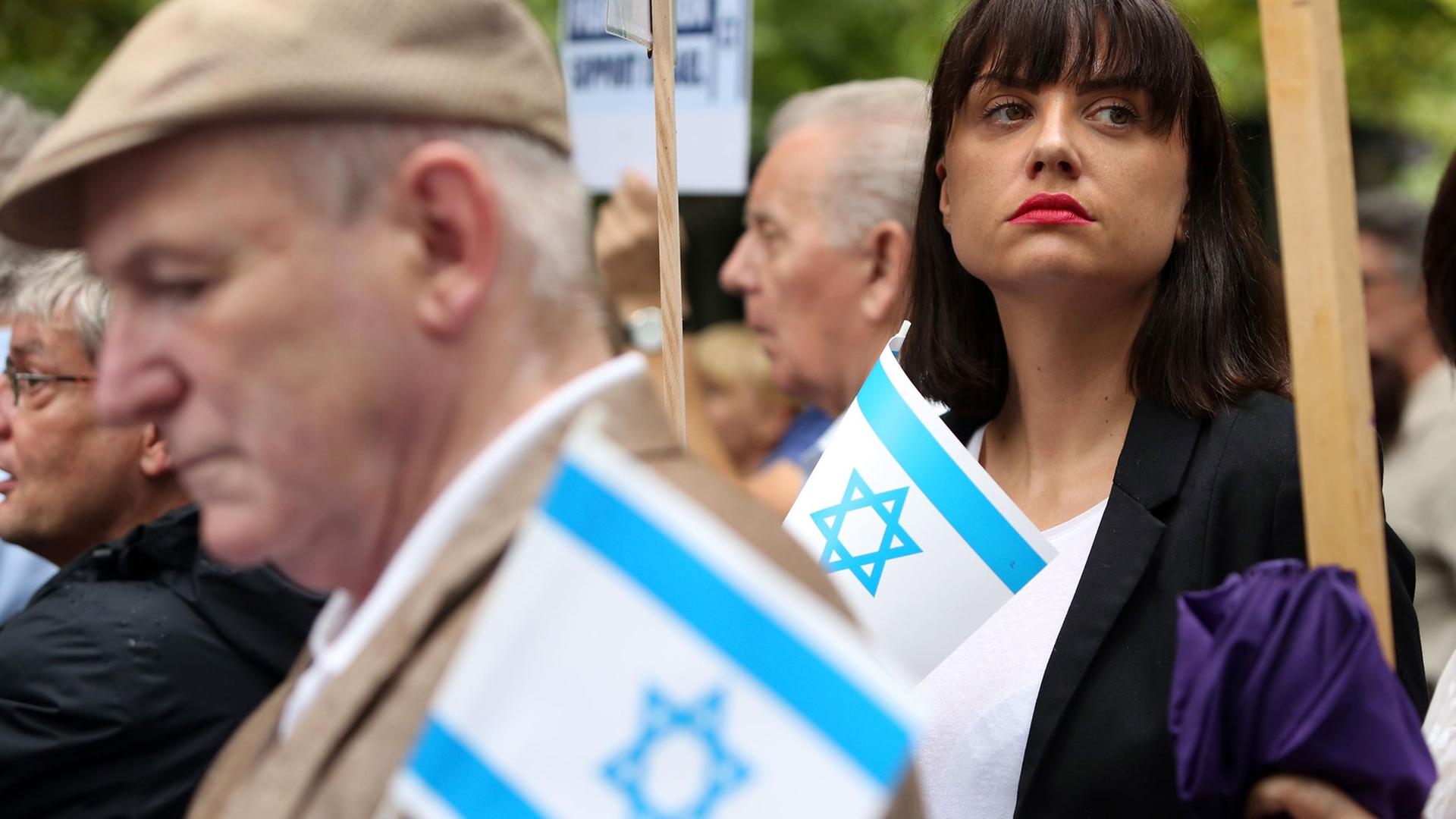 Demonstranten, die an einer Kundgebung gegen den pro-palästinensischen Al-Kuds-Tag in Berlin teilnehmen, halten kleine israelische Flaggen in den Händen. Demonstranten, die an einer Kundgebung gegen den pro-palästinensischen Al-Kuds-Tag in Berlin teilnehmen, halten kleine israelische Flaggen in den Händen.