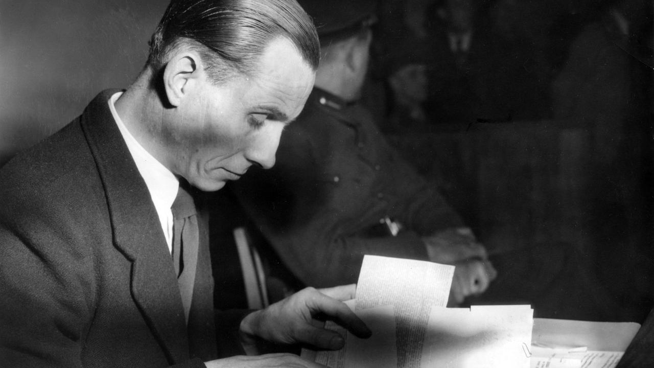 Otto Ernst Remer liest vor dem Landgericht Braunschweig in seinen Unterlagen. Er hatte die Beteiligten des Attentats auf Hitler als "Landesverräter" bezeichnet.Er war an der Niederschlagung des Umsturzversuchs nach dem Attentat auf Hitler am 20.07.1944 beteiligt. Otto Ernst Remer liest vor dem Landgericht Braunschweig in seinen Unterlagen. Er hatte die Beteiligten des Attentats auf Hitler als "Landesverräter" bezeichnet.Er war an der Niederschlagung des Umsturzversuchs nach dem Attentat auf Hitler am 20.07.1944 beteiligt.