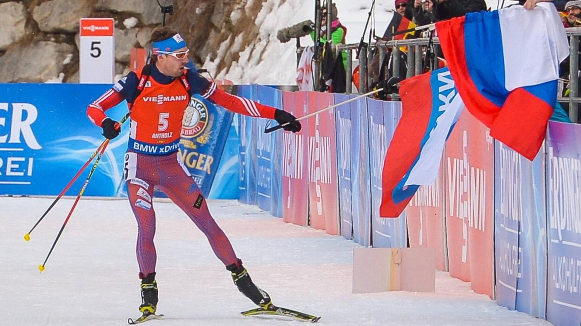 Der russische Biathlet Anton Shipulin hält eine russische Flagge, während er die Verfolgung der Männer beim Biathlon-Weltcup in Antholz in der Saison 2015/16 gewinnt. Der russische Biathlet Anton Shipulin hält eine russische Flagge, während er die Verfolgung der Männer beim Biathlon-Weltcup in Antholz in der Saison 2015/16 gewinnt.