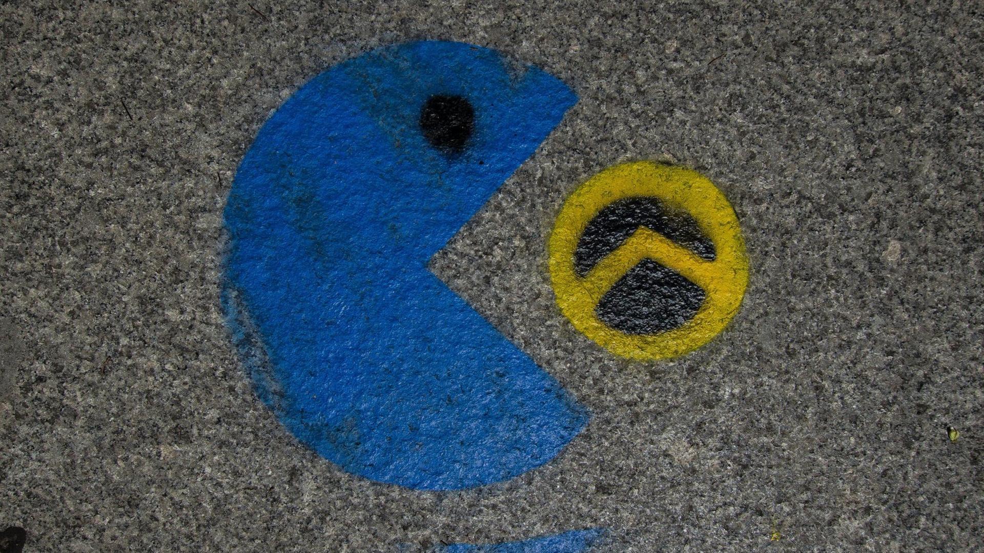 Ein Graffiti zeigt, wie ein blauer Pac-Man ein schwarz-gelbes Lambda-Zeichen der sogenannten Identitären Bewegung auffrisst. Ein Graffiti zeigt, wie ein blauer Pac-Man ein schwarz-gelbes Lambda-Zeichen der sogenannten Identitären Bewegung auffrisst.