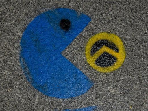 Ein Graffiti zeigt, wie ein blauer Pac-Man ein schwarz-gelbes Lambda-Zeichen der sogenannten Identitären Bewegung auffrisst.