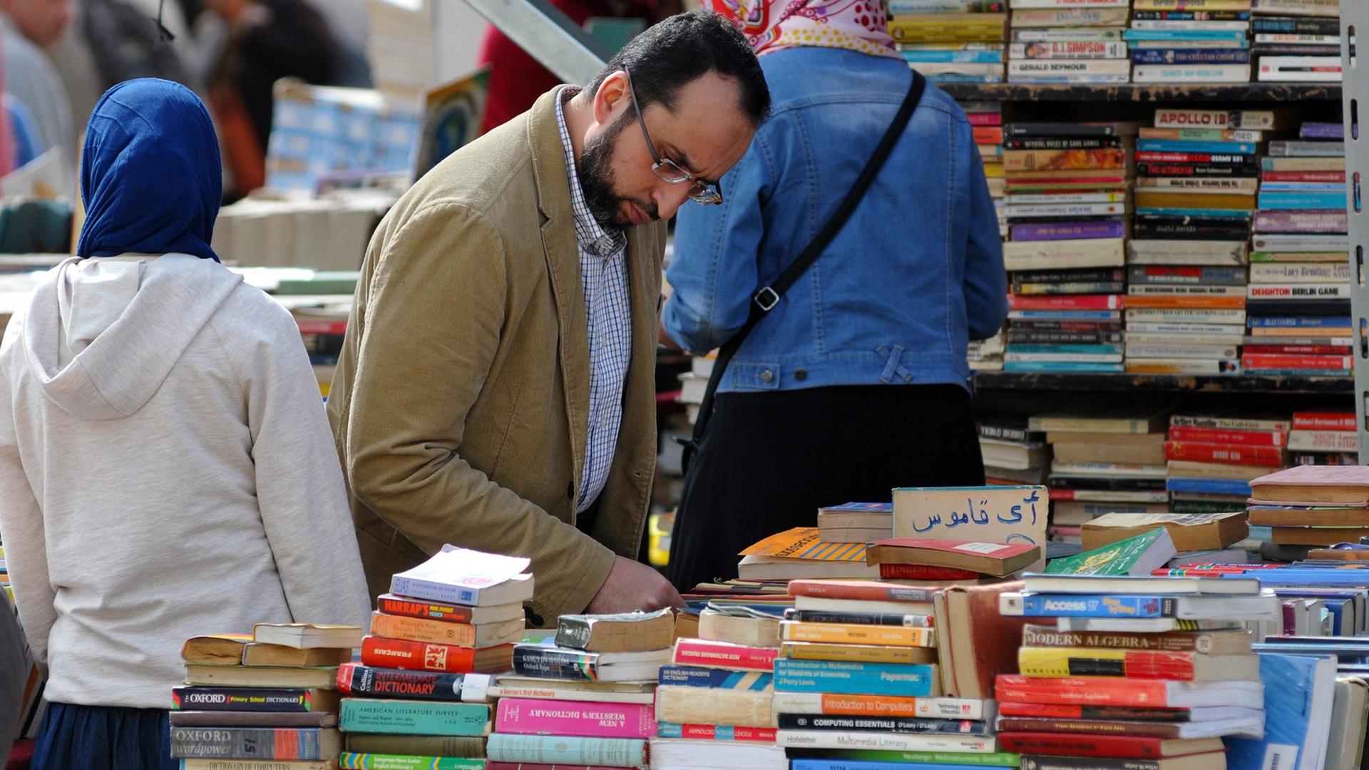 Ein Mann an einem Büchertisch Ein Mann an einem Büchertisch