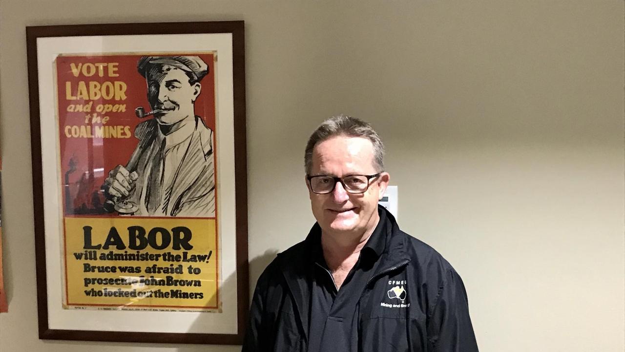 Ein untersetzter Mann mit Brille, gekleidet ganz in schwarz, steht neben einem Wahlplakat der Labor-Partei. Ein untersetzter Mann mit Brille, gekleidet ganz in schwarz, steht neben einem Wahlplakat der Labor-Partei.